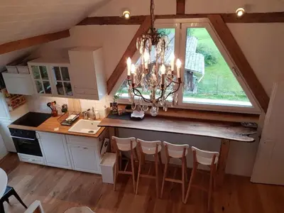 a kitchen with a chandelier and a large window at Apartment Studio Chic mit Whirlpool by Interhome in Wildhaus