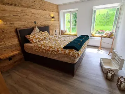 a bedroom with a bed with a wooden wall at Apartment Allegra Appenzell by Interhome in Trogen