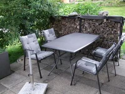 a table and chairs sitting next to a stone wall at Apartment Ballmoos Ferienwohnung by Interhome in Gais