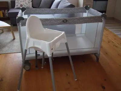 a white baby crib with a chair in a room at Apartment Ballmoos Ferienwohnung by Interhome in Gais