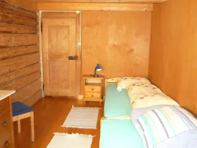 a bedroom with a bed and a table and a door at Holiday Home Appenzell House by Interhome in Thal