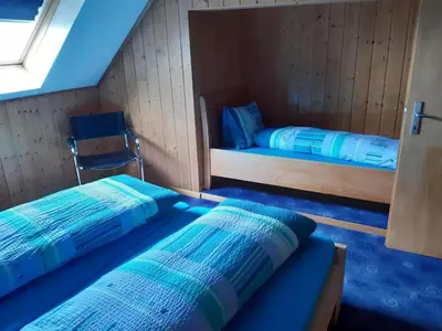 two beds in a small room with blue sheets at Apartment Löhli Hof by Interhome in Lienz