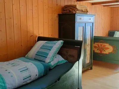 a bedroom with a bed and a wooden wall at Apartment Löhli Hof by Interhome in Lienz