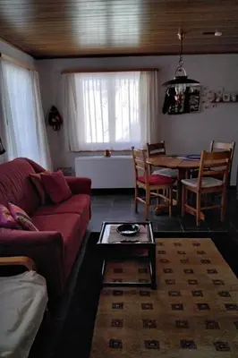 a living room with a red couch and a table at Holiday Home Feriehüsli by Interhome in Krummenau