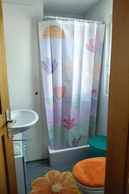 a bathroom with a shower curtain with a toilet and a sink at Holiday Home Feriehüsli by Interhome in Krummenau