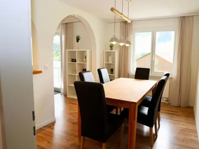 a dining room with a wooden table and black chairs at Apartment Panoramablick by Interhome in Nesslau