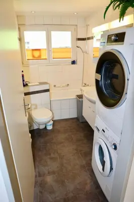a bathroom with a washing machine and a toilet at Apartment Panoramablick by Interhome in Nesslau