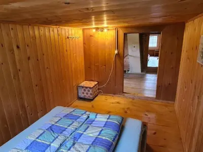 a bedroom with a bed in a wooden room at Holiday Home Seuzach by Interhome in Nesslau