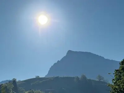 a sun rising over a hill with trees at Apartment Zwingli's Ferienwohnung by Interhome in Nesslau
