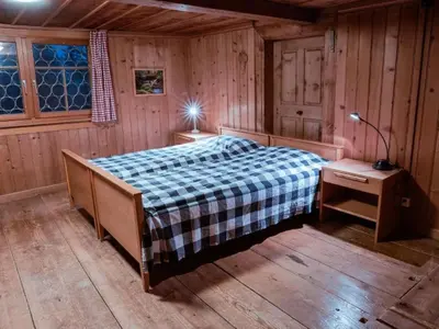 a bedroom with a bed in a wooden room at Holiday Home Alpenrösli in Nesslau by Interhome in Nesslau