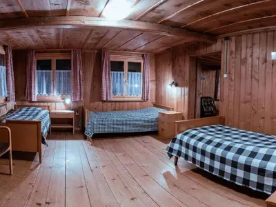 two beds in a room with wooden walls and wooden floors at Holiday Home Alpenrösli in Nesslau by Interhome in Nesslau