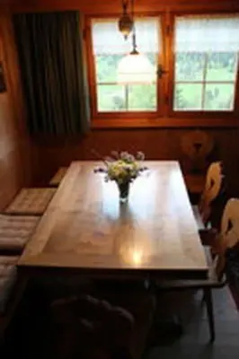a wooden table with a vase of flowers on it at Holiday Home Obere Laui by Interhome in Nesslau