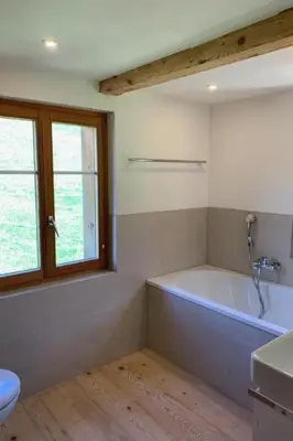 a bathroom with a tub and a sink and a window at Holiday Home Ferienhaus by Interhome in Nesslau
