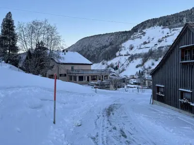 a snow covered street with a building and a mountain at Apartment Terrasse & Pistenähe by Interhome in Alt Sankt Johann