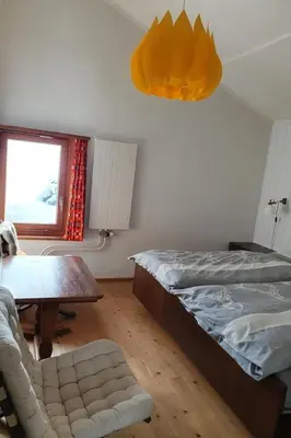 a bedroom with a bed and a table and a chair at Holiday Home Oberguet by Interhome in Unterwasser