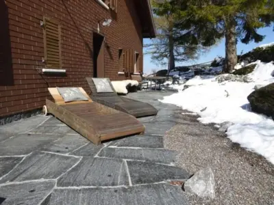 two wooden benches sitting on a stone patio at Holiday Home Oberguet by Interhome in Unterwasser