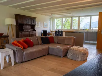 a living room with a brown couch with red pillows at Holiday Home Haus am Schwendisee by Interhome in Wildhaus