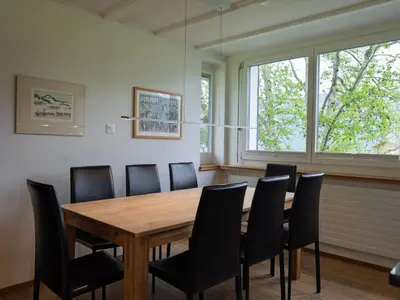 a dining room with a wooden table and black chairs at Holiday Home Haus am Schwendisee by Interhome in Wildhaus