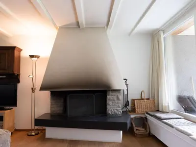 a living room with a brick fireplace with a tv at Holiday Home Haus am Schwendisee by Interhome in Wildhaus