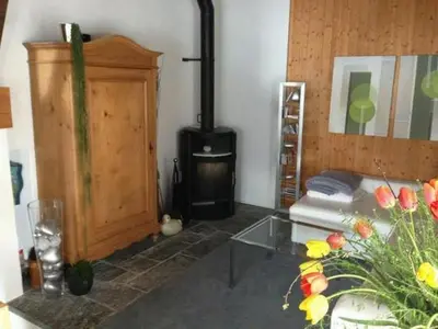a living room with a stove and a couch at Holiday Home Höckli by Interhome in Wildhaus