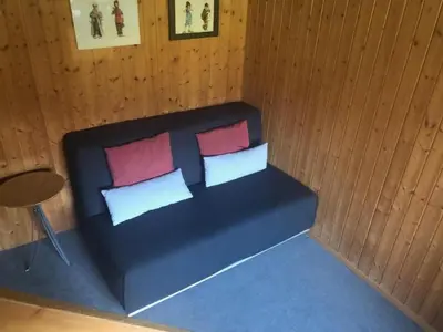 a bedroom with a bed with three pillows and a table at Holiday Home Höckli by Interhome in Wildhaus