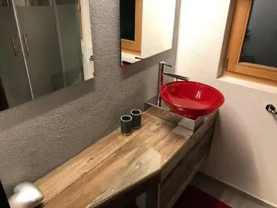 a bathroom with a red sink on a wooden counter at Holiday Home Höckli by Interhome in Wildhaus