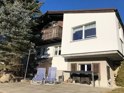 two blue chairs and a table in front of a house at Holiday Home Höckli by Interhome in Wildhaus