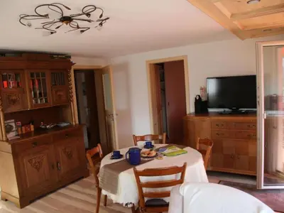 a dining room with a table with chairs and a television at Apartment Chalet Lilian by Interhome in Unterwasser