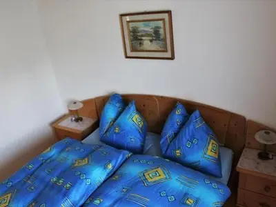 a bed with blue sheets and pillows on it at Apartment Chalet Lilian by Interhome in Unterwasser