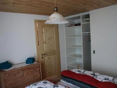 a bedroom with a bed and a dresser and a closet at Apartment Chalet Lilian by Interhome in Unterwasser