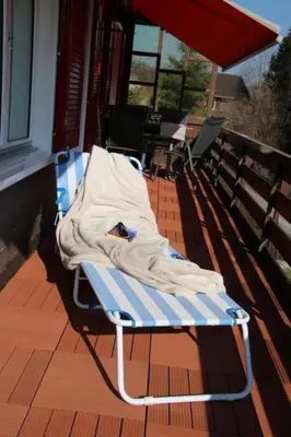 a blanket laying on a bench on a porch at Apartment Chalet Lilian by Interhome in Unterwasser