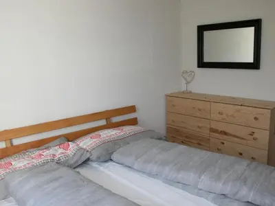 a bedroom with two beds and a dresser and a mirror at Apartment Bädli by Interhome in Wildhaus