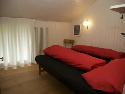 a room with two red pillows on a bed at Holiday Home Befang 17 by Interhome in Wildhaus