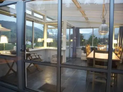 a dining room and living room with sliding glass doors at Holiday Home Befang 17 by Interhome in Wildhaus