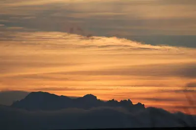 a sunset with clouds and mountains in the background at Charming Retreat for Nature Lovers near Saxerlücke in Sennwald