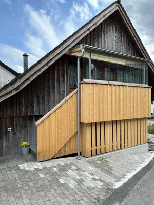a wooden building with a large wooden garage at Charming Retreat for Nature Lovers near Saxerlücke in Sennwald