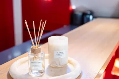 a bottle of candle and bamboo sticks on a table at BLIV Exklusive Dachgeschosswohnung im Zentrum in St. Gallen