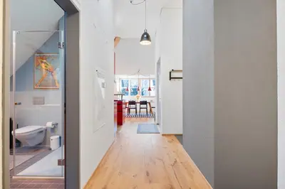 a hallway of a home with white walls and wooden floors at BLIV Exklusive Dachgeschosswohnung im Zentrum in St. Gallen