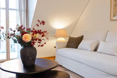 a living room with a vase of flowers on a table at BLIV Exklusive Dachgeschosswohnung im Zentrum in St. Gallen