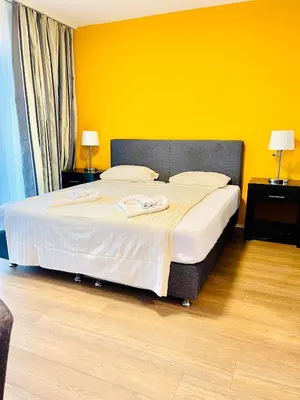 a bedroom with a large bed with a yellow wall at Hotel Swiss Bellevue in Kreuzlingen