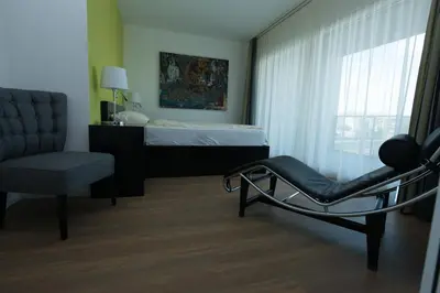 a bedroom with a chair and a bed with a window at Hotel Swiss Bellevue in Kreuzlingen