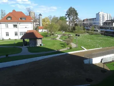 a view of a park next to a white building at Hotel Swiss Bellevue in Kreuzlingen