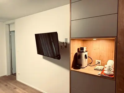 a coffee maker and cups on a wooden shelf at Comfort Rooms mit Whirlpoolzugang in Romanshorn
