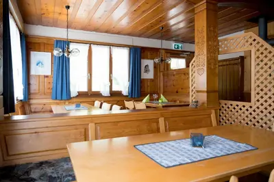 a dining room with a table and blue curtains at Berggasthaus Voralp in Grabs
