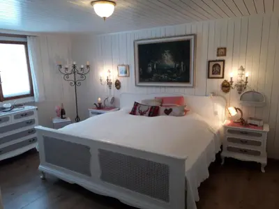a bedroom with a large white bed with pillows at Chalet Chic mit Hot Pot in Wildhaus