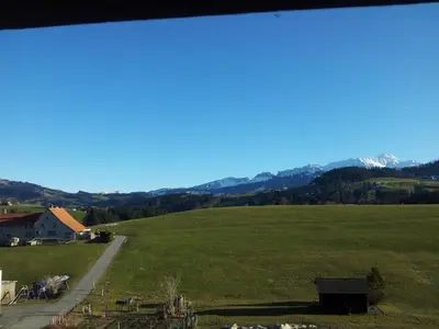 a large green field with mountains in the background at Hotel Garni Traube B&B in Schwellbrunn
