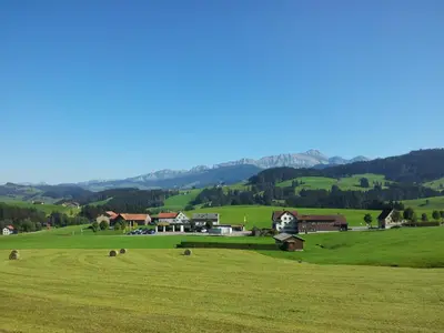 a green field with a house in the middle at Hotel Garni Traube B&B in Schwellbrunn