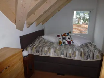 a bed in a room with a window at Hotel Enjoy in Goldach