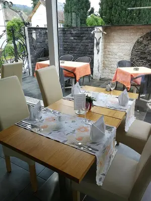 a wooden table with chairs and a table cloth on it at Hotel Enjoy in Goldach