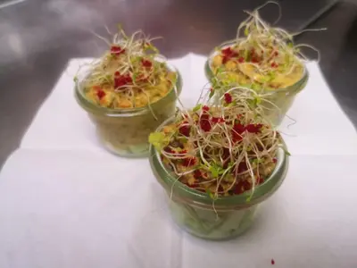 four plastic cups filled with plants on a table at Hotel Enjoy in Goldach